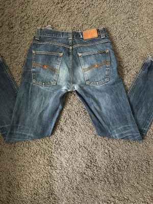 Nudie jeans grim tim - Säljer ett par blå Nudie jeans i modellen  Grim Tim. Jeansen har en riktigt fet tvätt och är i storleken W31 L32. Skriv vid ytterligare frågor!
