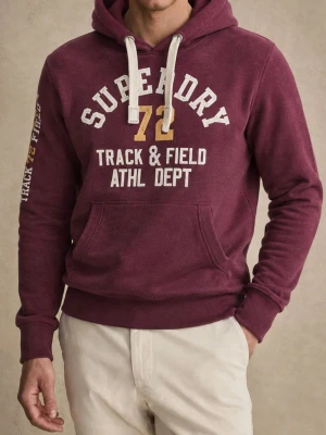Vinröd hoodie från Superdry - Snygg vinröd hoodie från Superdry . Hoodien har vit dragsko, känguruficka och ribbade muddar. Mjuk bomullsblandning och detaljerat tryck även på ena ärmen. Perfekt för en sportig och avslappnad stil.