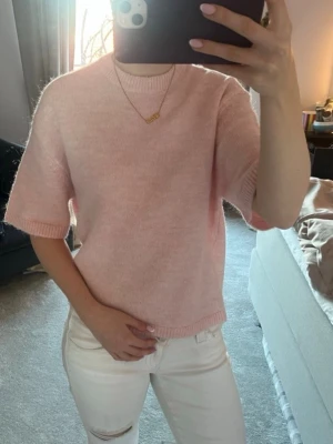 Ljusrosa stickad topp - Supersöt ljusrosa stickad topp med korta ärmar och rund hals. Perfekt till jeans eller kjol för en chill och trendig look. Aldrig använd och prislappen kvar på tröjan☺️
