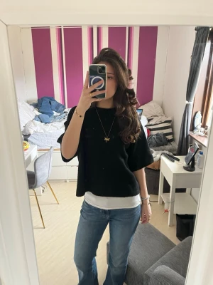 Svart stickad t-shirt - Säljer en svart stickad T-shirt . Tröjan har en enkel, stilren design och är perfekt att matcha med jeans eller kjol. Materialet ser mjukt och bekvämt ut, och modellen är något croppad. Säljer då den inte kommit till användning💕