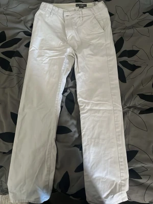 Vita chinos från H&M L.O.G.G. - Snygga vita chinos från H&M:s L.O.G.G.-kollektion. Klassisk rak passform med bälteshällor och sidofickor. Tillverkade i ett mjukt bomullstyg som känns bekvämt hela dagen. Perfekta för en clean och stilren look.