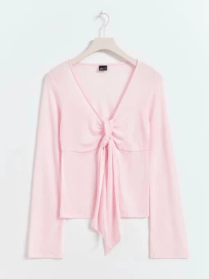 Ljusrosa långärmad knytblus - Trendig ljusrosa långärmad topp med v-ringning och snygg knytning framtill. Perfekt att styla med jeans eller kjol för en cool look. Mjuk och lätt i materialet, vilket gör den skön att bära hela dagen.