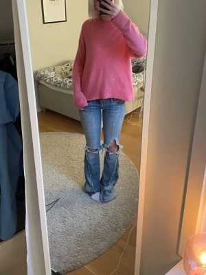 Rosa oversized stickad tröja - Säljer en oversized stickad tröja i en härlig rosa färg. Tröjan har rund halsringning, långa ärmar och ribbade muddar vid ärmslut och nederkant. Perfekt för dig som gillar en avslappnad och trendig stil.