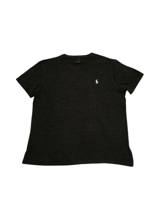 Svart t-shirt från Polo Ralph Lauren - Klassisk svart t-shirt från Polo Ralph Lauren med rund halsringning och korta ärmar. Diskret logga broderad i vitt på bröstet. Tillverkad i mjuk    bomull för en skön och avslappnad passform.      📍Storlek:M  💪🏽Skick: bra   📐Mått:Längd:66cm:Bred:48:cm:  📎Material:100%Bomull  📦Skickar alltid inom 48h  ✅Äkthetsgaranti