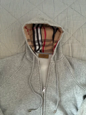 Grå Burberry Hoodie - Säljer då en Burberry Hoodie Som Blir Perfekt Nu Till Sommaren. Snörerna Till Hoodien Har Jag Tyvärr Dragit Ut, Men Kan Skicka Med Dem i Paketet. Har Ej Kvitto 😁