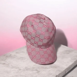 Rosa keps med mönster - Säljer en snygg rosa keps med det klassiska monogrammet över hela kepsen. Kepsen har böjd skärm och är tillverkad i ett tygmaterial med struktur. Perfekt accessoar för att lyfta din outfit.
