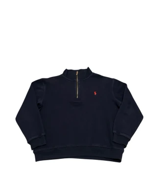 Mörkblå half-zip tröja från Polo Ralph Lauren - Snygg mörkblå half-zip sweatshirt från Polo Ralph Lauren med klassisk röd logga broderad på bröstet. Tröjan har hög krage, dragkedja framtill och ribbade muddar vid ärmar och nederkant. Perfekt för en chill och stilren look.                        📍Storlek:S/XS  💪🏽Skick:Mycket bra   📐Mått:Längd:56:cm:Bred:48:cm:  📎Material:100%Bomull:  📦Skickar alltid inom 48h  ✅Äkthetsgaranti 