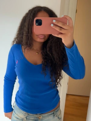 Blå ralph lauren tröja med rosa märke - Säljer denna superfina långärmade tröjan från ralph lauren med rosa logga🩷