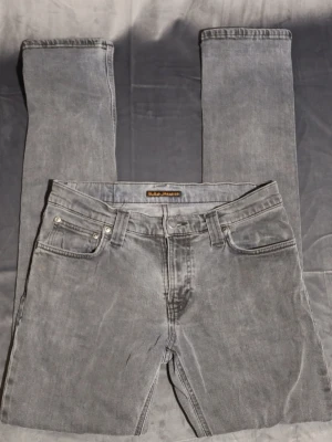 Nudie jeans  - Det här är ett par jeans från Nudie Jeans Co i mörk tvätt. De verkar vara i gott skick med mindre tecken på slitage.  ⭐️ Skick: 7/10 (Mindre tecken på slitage) 🎲 Storlek: 29/34 📦 Snabb och noggrann frakt.                                     Hör av dig vid funderingar mvh Melwin😁🙌