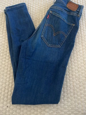 Mörkblå Levi's jeans med rak passform - Snygga mörkblå jeans från Levi's med klassisk rak passform och femficksdesign. Jeansen har tydliga kontrastsömmar och den ikoniska röda Levi's-taggen på bakfickan. Tillverkade i slitstark denim av bomull. Fullt fungerande kedja litet slitage under knät  mjuka stretchiga sköna 