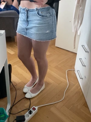 Ljusblå jeanskjol med rå kant -  Ljusblå jeanskjol med rå, fransad kant och klassiska fickor från Pull & Bear i storlek S. Jeanskjol har två stycken små defekter vilket är några prickar av målarfärg som borde gå bort i tvätten. Kjolen köptes för 2 år sedan men har endast använts några gånger på somrarna, säljer den då den börjar bli för liten.