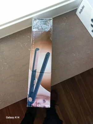 Svart plattång från BaByliss - En stilren svart plattång från BaByliss, perfekt för att styla håret hemma. Plattången har en klassisk rak design med släta plattor och ett smidigt handtag. Materialet är plast och metall, och den kommer i originalförpackning.