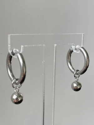 Silvriga hoops med hängande pärlor - Snygga örhängen i silver, rostfritt stål, allergi vänliga med rund hoop-design och små hängande kulor i stål. Enkla men trendiga, perfekta för att lyfta vilken outfit som helst. Passar dig som gillar minimalistisk stil med en twist.