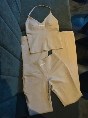 Beige set från DFYNE med topp och tights - Säljer ett beige set från slutsålda Hannah Pearson med DFYNE. Mjukt och stretchigt material som sitter skönt på kroppen. Perfekt för en trendig och sportig look. Toppen är i xs och byxorna i s