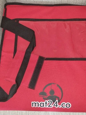 Röd leveransväska med axelrem - Säljer en röd leveransväska från mat24.co med svart axelrem och detaljer. Väskan är tillverkad i slitstark textil och har ett stort fack med svart insida, perfekt för att bära mat eller andra saker. Praktisk och rymlig design med kardborreband.
