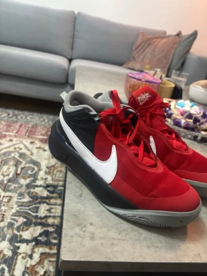 Nike röda och svarta sneakers - Snygga sneakers från Nike i rött och svart med vit swoosh på sidan. Skorna har grå sula och röda skosnören. Ovandelen är i mesh och syntetmaterial för bra andningsförmåga och komfort. Perfekta för dig som gillar sportig stil.