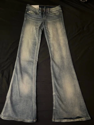Blå utsvängda jeans från Cheap Monday - Säljer ett par blå utsvängda jeans från Cheap Monday, modellen heter BOOTY BEI. Dessa jeans är endast testade. Storlek: 26/32