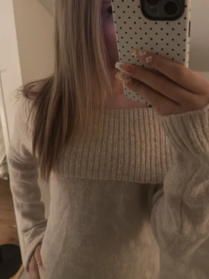 Beige off shoulder stickad tröja - Mysig beige stickad tröja med bred ribbad kant upptill som går att bära off shoulder. 💕💞Tröjan har långa ärmar och ribbade muddar vid ärmslut och nederkant. ❤️Perfekt för dig som gillar en avslappnad men ändå trendig stil. 🤍 Inga fläckar samt hål, andvänd fåtals gånger!💗ord pris:≈350 nu pris:150kr( kan sänka) 💓