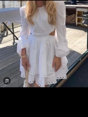 Vit klänning med cut-outs och puffärm  - Supersöt vit kortklänning med cut-outs på sidorna och puffärmar