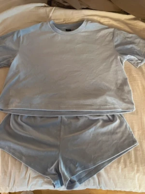 Ljusblått loungewear set - Mysigt loungewear set i ljusblått med en oversized t-shirt och matchande shorts. Materialet ser mjukt och stretchigt ut, perfekt för chill dagar hemma. Shortsen har resår i midjan för extra komfort.