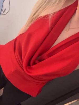 Röd  halterneck topp - Snygg röd halterneck topp med omlott-drapering framtill. Toppen är ärmlös och har en djup v-ringning som ger en cool och trendig look. Perfekt att styla med jeans eller kjol för en chic outfit. Från bokbok, strl L