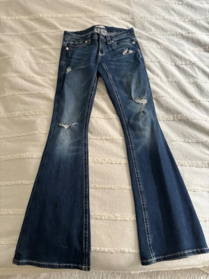Blå bootcut jeans med slitningar - Säljer ett par blå bootcut jeans med slitningar och snygga detaljer på fickorna baktill, ifrån Gina tricot 14+ i storlek S. Jeansen har en klassisk femficksmodell, passar till allt och är nästan helt oanvända🩷
