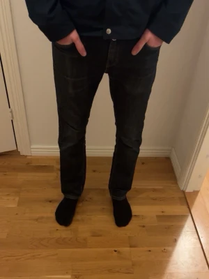 Mörkblå slim fit  jeans från Levi's - Säljer ett par mörkblå jeans från Levi's med klassisk rak passform och snygga kontrastsömmar. Jeansen har fem fickor och Levi's röda logga på bakfickan. Perfekta för en avslappnad och stilren look. Skriv för mer info