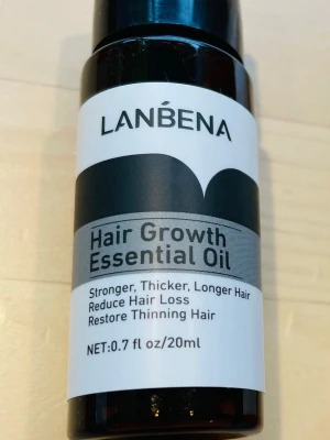  Hair Growth Essential Oil -  Hair Growth Essential Oil, 20 ml, hjälper till att stärka, förtjocka och förlänga håret. Oljan minskar håravfall och återställer tunt hår. Kommer i en brun plastflaska med svart och vit etikett.
