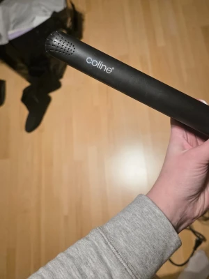 Svart plattång från Coline - Säljer en svart plattång från Coline med slimmad design och rundade kanter. Plattången har en enkel knapp för att slå på och värmereglering