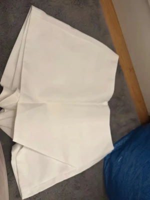 Vita skorts kjol - Stilrena vita skorts med rak passform och en diskret ficka bak. Klassisk design med omlott framtill som ger en modern look. Perfekta för dig som vill ha både kjol och shorts i ett plagg. Materialet känns mjukt och har en lätt struktur. För fler bilder/information skriv gärna, priset kan justeras 🤗❤️