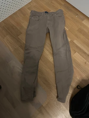 Beige chinos från Gant - Snygga beige chinos från Gant med klassisk femficksdesign och smal passform. Tillverkade i mjukt bomullstyg med lite stretch för extra komfort. Perfekta för en avslappnad men stilren look.