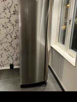 Rostfritt kylskåp med flera hyllor - Snyggt kylskåp i rostfritt stål med flera justerbara glashyllor och rymliga dörrfack. Kylskåpet har modern design och LED-belysning invändigt. Perfekt för dig som vill ha gott om plats för mat och dryck i köket.