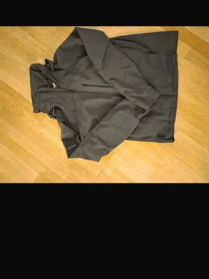 Svart vindjacka med huva - Snygg svart vindjacka med dragkedja framtill och praktisk huva. Passar till allt säljer pågrund av för liten tyvär nypris 2600 ungefär passar mellan 165-180 bara höra av er vid frågor !