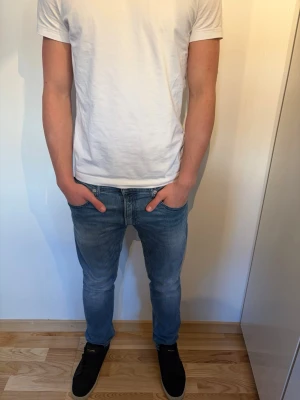Ljusblå Replay jeans - Säljer ett par blå slim fit jeans med klassisk femficksdesign och normal midja. Jeansen har en snygg tvättad look och raka ben. Perfekta till vardagsstilen och passar till det mesta. Inga synliga detaljer som sticker ut, bara clean och enkel design.