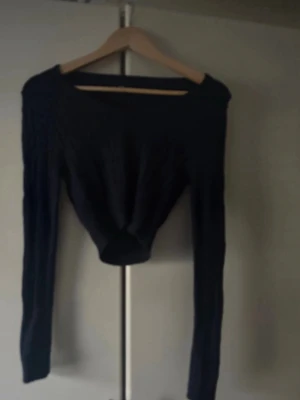 Mörkblå croppad stickad tröja - Snygg mörkblå stickad tröja med croppad passform och långa ärmar. Tröjan har en bred, rundad halsringning och ribbade detaljer längs hela plagget. Perfekt för dig som gillar en trendig och enkel stil. För fler bilder/information skriv gärna, priset kan justeras 🤗❤️