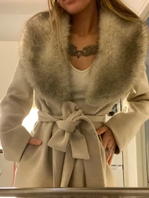 Beige kappa  - Stilren beige kappa med bred krage. Lång modell med raka ärmar och mjukt material som ger en lyxig känsla. Aldrig använd 💕