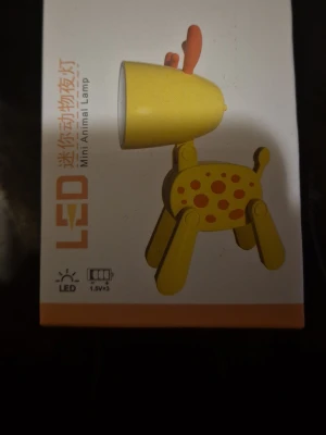 Gul LED Mini Animal Lampa - Säljer en söt gul LED-lampa formad som ett djur, perfekt som nattlampa eller dekoration. Lampan har orange prickar och detaljer samt fyra ben. Tillverkad i ABS-plast och drivs av tre AG3-batterier. Smidig och rolig design som passar på skrivbordet eller nattduksbordet.