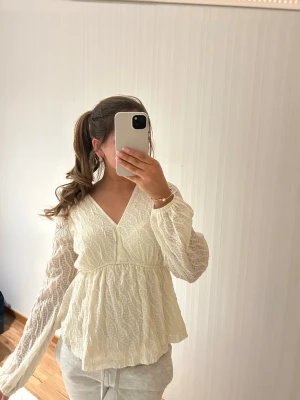 Vit blus med struktur - Superfin vit blus med v-ringning och långärmade ärmar, har sytt lite i v-ringningen för den var väldigt djup men inget som syns