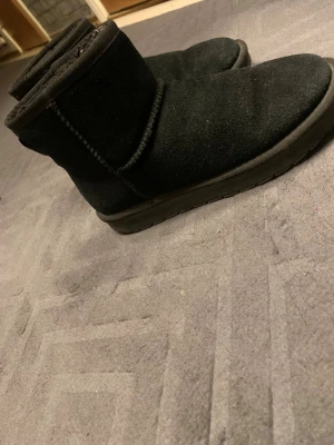 Svarta uggs - Säljer ett par svarta moon boots med mjuk insida och klassisk rundad tå. Från din sko. Defekter förekommer men det är bara för de är använda, så inga hål eller fläckar som ej går bort. 