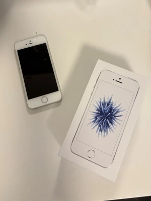FYND! iPhone SE + Originalkartong & Skal – Endast 1500  kr!  - Säljer en välfungerande iPhone SE som är redo för en ny ägare. Perfekt för dig som vill ha en snabb och smidig iPhone utan att behöva lägga flera tusen kronor.  📦 Detta ingår: ✅ Originalkartong ✅ Plånboksfodral/skal ✅ Fullt fungerande telefon  Telefonen är i fint skick och fungerar bra. Batteriet är använt, vilket är normalt för en begagnad mobil, och därför är priset extra förmånligt.  💰 Nypris: 2 670 kr 🔥 Säljes för 1 500 kr eller rimligt bud!  📩 Skicka meddelande vid intresse. Seriösa köpare 