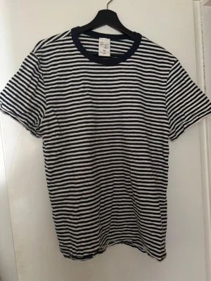 Roy Slub Stripe T-Shirt Blue/Offwhite - Vit och navyblå randig nudie T-shirt i storlek medium. T-shirten är endast använd ett fåtal gånger och i mycket bra skick!