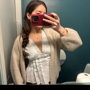 Vit spetsblus med v-ringning - Heter ”broderie anglaise blouse” på ginatricot. Söt vit blus med v-ringning och broderade spetsdetaljer. Blusen har korta ärmar, dekorativa veck framtill och en vågig kant längst ner. Perfekt för en trendig och feminin look. Materialet är lätt och luftigt, vilket gör den skön att bära. 