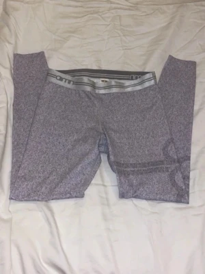 Gråa tränibgsleggings från Aim'n - Säljer ett par gråa leggings från Aim'n med bred resår i midjan och logga på benet. Materialet är stretchigt. Storlek M