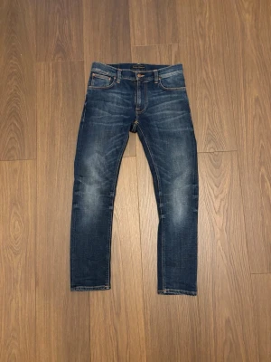 Nudie jeans - Säljer ett par snygga blå nudie jeans med lätta slitningar och en perfekt smal passform. Fråga vid minsta fundering (svarar snabbt)
