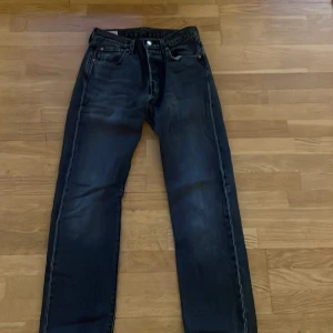 Levis 501 jeans - Säljer ett par svarta Levis 501 jeans i storlek W28 L30. De har en relaxed passform och är i bra skick förutom en deffekt som man kan se på sida 4. Hör av er vid frågor