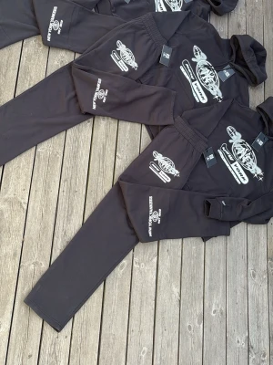 New Era tracksuit - Svart hoodie från New York Yankees med stor vit logga och tryck på bröstet samt ärmen. Klassisk huva och känguruficka framtill. Tillverkad i mjukt material som passar perfekt till en avslappnad streetwear-look. 800kr/tracksuit