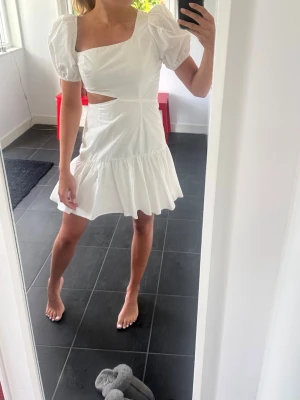 Vit kort klänning  - Snygg vit kort klänning med cut-out detalj i midjan. Klänningen är från ASTR the label i storlek xs. Den är i mycket bra skick, endast använd en gång 💕köparen står för frakt. 