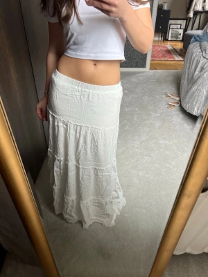 Maxikjol - Vit maxikjol med små volanger. Mjukt och tjockt material, så den är inte genomskinlig.