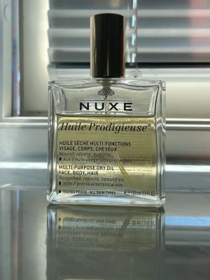 Nuxe Huile Prodigieuse torr olja - Nuxe Huile Prodigieuse är en multifunktionell torr olja för ansikte, kropp och hår. Kommer i en elegant, fyrkantig glasflaska med guldfärgad pump, är berikad med sju vegetabiliska oljor som ger näring och lyster utan att kännas fet.