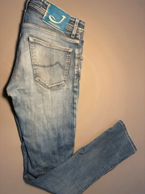 Ljusblå jeans från Jacob Cohen - Säljer ett par ljusblå jeans från Jacob Cohen med klassisk femficksmodell och knappgylf. Jeansen har en snygg tvätt med en blå patch med logga bak i midjan. Materialet är mjukt denim som sitter skönt och följsamt, nypris:5000kr mitt pris 699kr (hör av er vid funderingar 😁)